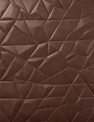 The primary subject of the image is a brown leather material, which appears to be a piece of leather or a leather-like fabric. The setting is a close-up view of the material, showcasing its texture and pattern. The visual style is a close-up of the leather material, which gives it a realistic and textured appearance. The colors and mood of the image are predominantly brown, giving it a warm and natural feel.