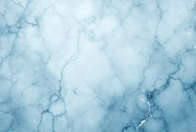 The primary subject of the image is a blue marble wall with a white and blue marble pattern. The setting is a room with a blue marble wall, and the visual style is a photo. The dominant colors are blue and white, creating a calm and serene atmosphere.