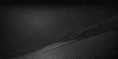 The primary subject of the image is a close-up of a black surface with a pattern of thin lines. The setting appears to be a dark room, and the visual style is a black and white photo. The dominant colors are black and white, and the overall atmosphere is somewhat mysterious or dramatic.