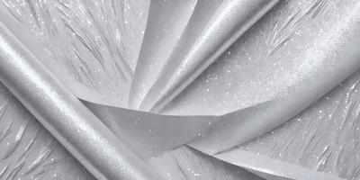 The primary subject of the image is a silver spiral pattern, which appears to be a piece of fabric or a decorative element. The setting is a close-up view of the spiral pattern, showcasing its intricate details. The visual style is a combination of a photo and digital art, as the spiral pattern is both realistic and artistic. The colors and mood of the image are predominantly silver and metallic, giving it a sleek and modern appearance.