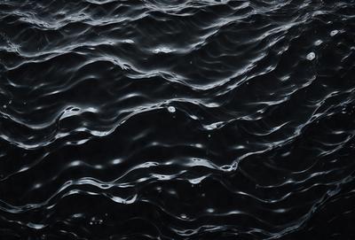 The primary subject of the image is a black and white photo of a body of water, possibly an ocean or a lake. The setting is a dark, possibly stormy, environment, with the water appearing to be rough and choppy. The visual style is a black and white photo, which adds a sense of depth and intensity to the scene. The colors and mood of the image are dark and moody, with the water and sky creating a dramatic atmosphere.