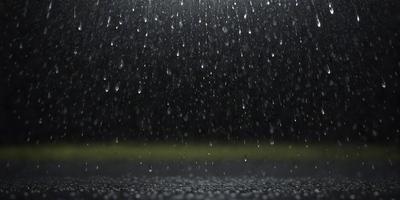 The primary subject of the image is a rainy night scene with a focus on the rain falling on the ground. The setting is a dark, rainy night with a backdrop of a dark sky. The visual style is a photo, capturing the raindrops on the ground. The colors and mood of the image are dominated by the darkness and the sound of the rain, creating a moody and atmospheric scene.