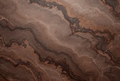 The primary subject of the image is a close-up of a marbled surface, possibly a piece of wood or a stone. The setting is a dark room, and the visual style appears to be a close-up of a textured surface. The colors and mood of the image are dark and moody, with the marbled surface being the main focus.