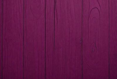 The primary subject of the image is a purple wooden wall. The setting is a room with a wooden surface, and the visual style is a close-up of the wall. The dominant colors are purple and brown, creating a warm and inviting atmosphere.