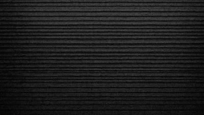 The image is a black and white photo of a wall with a patterned texture. The wall appears to be made of wood and has a unique design. The overall atmosphere of the image is somewhat dark and moody, with the black and white color scheme adding to the dramatic effect.