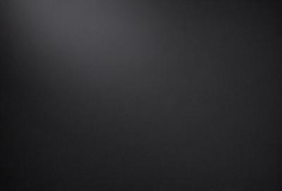 The primary subject of the image is a black background with a white light source. The setting is a dark room, and the visual style is a black and white photo. The colors and mood of the image are predominantly dark and moody, with the white light source creating a stark contrast against the black background.