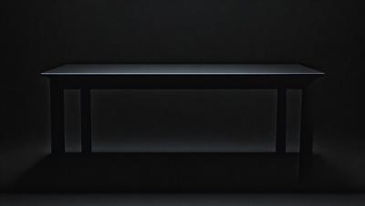 The primary subject of the image is a black countertop. The setting is a dark room, and the visual style is a black and white photo. The countertop appears to be a part of a larger structure, possibly a cabinet or a piece of furniture. The overall atmosphere of the image is dark and moody, with the black countertop and the dark room creating a sense of mystery or intrigue.