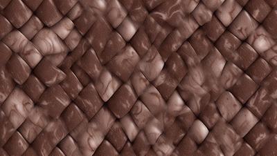 The primary subject of the image is a close-up of a brown, woven fabric with a pattern of marbled swirls. The setting is a wall, and the visual style appears to be a photo. The colors and mood of the image are warm and earthy, with the brown fabric creating a sense of texture and depth.