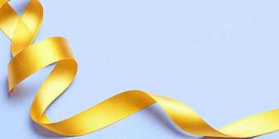 The primary subject of the image is a yellow ribbon. The ribbon is tied in a bow and is placed on a white background. The visual style of the image is a close-up of the yellow ribbon, showcasing its texture and color. The colors and mood of the image are predominantly yellow, creating a warm and inviting atmosphere.
