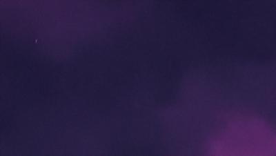 The image is a purple background with a dark, cloudy sky. The primary subject is a large, empty space with no visible objects or people. The setting is a vast, open area with no discernible landmarks or features. The visual style is a simple, monochromatic design with no intricate details or patterns. The colors and mood are predominantly dark and moody, with the purple hue creating a sense of depth and mystery.