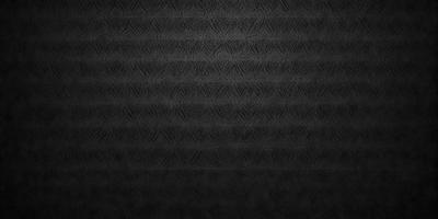The primary subject of the image is a black and white patterned fabric. The setting is a black background, which contrasts with the patterned fabric. The visual style is a close-up of the fabric, showcasing its intricate design. The colors and mood of the image are predominantly black and white, giving it a classic and timeless appearance.