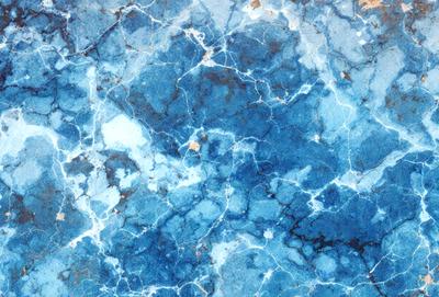 The primary subject of the image is a blue marble-like surface with a pattern of holes and bumps. The setting is a blue background, and the visual style appears to be a combination of a photo and a digital art or illustration. The dominant colors are blue and white, creating a calm and serene atmosphere.