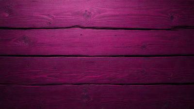 The primary subject of the image is a wooden surface, possibly a wooden floor or a wall, with a purple hue. The setting appears to be indoors, and the visual style is a close-up of the wooden surface. The colors and mood of the image are predominantly purple, creating a calm and serene atmosphere.