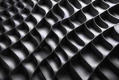 The primary subject of the image is a black and white patterned surface, which appears to be a black and white photo. The setting is a black background, and the visual style is a close-up of the pattern. The dominant colors are black and white, and the overall atmosphere is a modern and minimalist design.