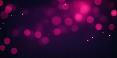 The primary subject of the image is a purple background with a pattern of pink dots. The setting appears to be a dark room, and the visual style is a close-up of the purple background with the pink dots. The colors and mood of the image are predominantly purple and pink, creating a warm and inviting atmosphere.