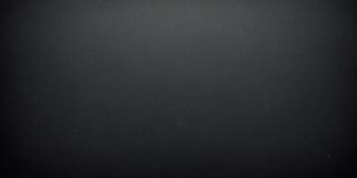The primary subject of the image is a black background with a leather texture. The setting is a dark room, and the visual style is a close-up of the leather surface. The colors and mood of the image are predominantly dark and moody, with the black background and leather texture creating a dramatic and intense atmosphere.