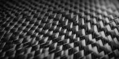 The primary subject of the image is a close-up of a black and silver patterned material, possibly a piece of fabric or a textured surface. The setting appears to be a black background, which contrasts with the patterned material. The visual style of the image is a close-up, focusing on the intricate details of the pattern. The colors in the image are predominantly black and silver, creating a sleek and modern atmosphere.