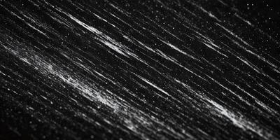 The primary subject of the image is a black background with white streaks or lines. The setting appears to be a dark room, and the visual style is a black and white photo. The dominant colors are black and white, creating a moody and dramatic atmosphere.