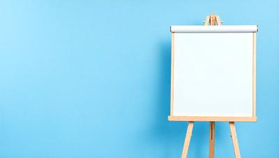 The primary subject of the image is a whiteboard, which is prominently displayed against a blue wall. The setting appears to be a classroom or a workspace, as the whiteboard is placed on a wooden easel. The visual style of the image is a photo, capturing the whiteboard and its surroundings in detail. The colors and mood of the image are predominantly blue, creating a calm and focused atmosphere.
