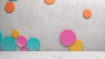 The primary subject of the image is a wall with a variety of colored circles attached to it. The circles are of different sizes and colors, creating a visually interesting and colorful display. The setting is a white wall, which provides a clean and neutral backdrop for the circles. The visual style of the image is a combination of digital art and illustration, as the circles are arranged in a pattern and the overall atmosphere is vibrant and lively.