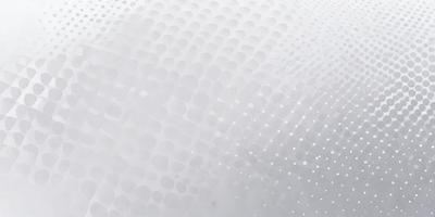 The primary subject of the image is a white surface with a pattern of small circles. The setting appears to be a white background, and the visual style is a close-up of the pattern. The dominant colors are white and grey, creating a clean and minimalist atmosphere.