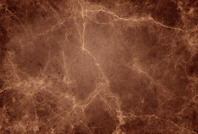 The primary subject of the image is a brown, textured wall with a patterned texture. The setting is a room with a brown wall, and the visual style is a close-up of the wall. The colors and mood of the image are warm and earthy, with a focus on the brown tones of the wall.