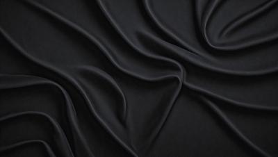 The primary subject of the image is a black fabric, which appears to be a piece of cloth or a curtain. The setting is a dark background, which contrasts with the black fabric. The visual style is a close-up of the fabric, showcasing its texture and details. The colors and mood of the image are predominantly dark, with the black fabric being the main focus.