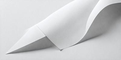 The primary subject of the image is a white sheet of paper. The paper is folded in a way that it appears to be a wave or a curved shape. The setting is a white background, which provides a clean and minimalistic appearance. The visual style of the image is a close-up of the paper, emphasizing its texture and details. The colors and mood of the image are predominantly white, giving it a clean and simple appearance.