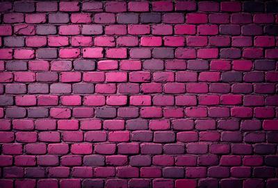 The primary subject of the image is a brick wall with a pinkish hue. The setting is a brick wall, and the visual style is a photo. The dominant colors are pink and purple, creating a warm and inviting atmosphere.