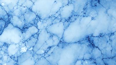 The primary subject of the image is a blue marble wall with a white and blue pattern. The setting is a room with a blue marble wall, and the visual style is a photo. The dominant colors are blue and white, creating a calm and serene atmosphere.