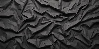 The primary subject of the image is a black paper with a wrinkled texture. The setting is a black background, and the visual style appears to be a close-up of the paper. The colors and mood of the image are predominantly dark and moody, with the black paper being the main focus.