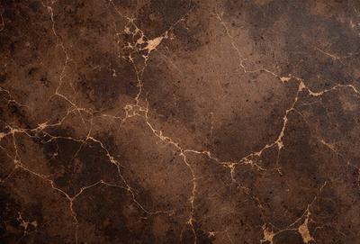 The primary subject of the image is a brown marble-like surface with a pattern of bumps and grooves. The setting is a close-up of the surface, showcasing its unique texture. The visual style is a close-up of the marble, which gives it a natural and textured appearance. The colors and mood of the image are warm and earthy, with the brown marble creating a sense of depth and richness.