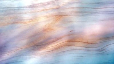 The primary subject of the image is a wooden surface with a patterned texture. The setting is a room with a window, and the visual style appears to be a photo. The dominant colors in the image are orange and blue, creating a warm and inviting atmosphere.