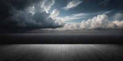 The primary subject of the image is a wooden floor with a view of the ocean. The setting is a beach, and the visual style is a black and white photo. The dominant colors are shades of gray, and the overall atmosphere is serene and peaceful.
