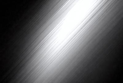 The primary subject of the image is a long, thin, and bright light source, which appears to be a light bulb. The light is shining down a long hallway, creating a sense of depth and dimension. The setting is a dark room, with the light source being the main focus of the image. The visual style is a black and white photo, which adds a timeless and classic feel to the scene. The colors and mood of the image are predominantly dark, with the bright light source serving as the main source