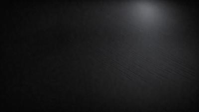 The image is a black and white photo of a dark room. The primary subject is a long, thin line that runs horizontally across the room. The setting is a dark room, and the visual style is a black and white photo. The colors and mood are dark and moody, creating a sense of mystery and intrigue.
