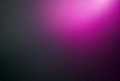 The primary subject of the image is a pink background. The setting is a dark room, and the visual style appears to be a photo. The dominant colors are pink and purple, creating a warm and inviting atmosphere.