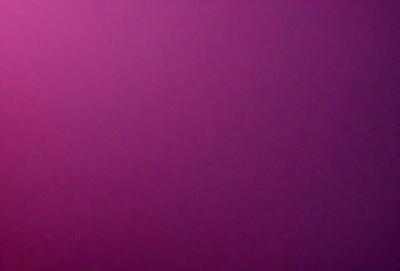 The primary subject of the image is a large, purple wall. The setting is a room with a pink background. The visual style is a close-up of the purple wall, which gives a sense of depth and texture. The dominant colors are purple and pink, creating a warm and inviting atmosphere.
