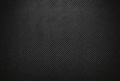 The primary subject of the image is a black background with a pattern of alternating black and white stripes. The setting is a dark room, and the visual style is a close-up of the black and white pattern. The colors and mood of the image are predominantly dark and moody, with the black and white stripes creating a sense of depth and contrast.
