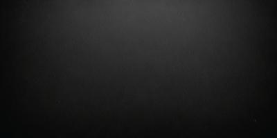 The primary subject of the image is a black background. The setting is a dark room, and the visual style is a black and white photo. The colors and mood of the image are dark and moody, creating a sense of mystery or drama.