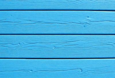 The primary subject of the image is a blue wooden wall. The setting is a room with a blue wooden wall, and the visual style is a photo. The dominant colors are blue and white, creating a calm and serene atmosphere.