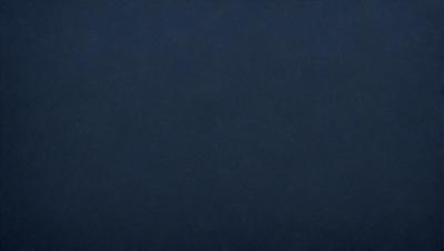 The primary subject of the image is a dark blue background. The setting is a vast, empty space with no visible objects or people. The visual style is a simple, monochromatic design. The colors and mood are predominantly dark and moody, with a hint of mystery.