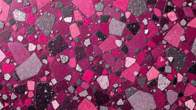 The primary subject of the image is a close-up of a purple and black marbled surface. The setting is a room with a purple and black marbled floor. The visual style is a close-up of the marbled surface, which gives a sense of depth and texture. The colors and mood of the image are predominantly purple and black, creating a bold and striking appearance.