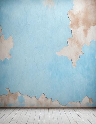 The primary subject of the image is a blue wall with a peeling paint texture. The setting is a room with a wooden floor. The visual style is a photo of the wall, showcasing the peeling paint and the blue color. The colors and mood of the image are predominantly blue, with a slightly aged and worn appearance due to the peeling paint.