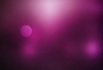 The primary subject of the image is a purple background with two pink circles in the foreground. The setting appears to be a dark, cloudy sky. The visual style is a combination of a photo and digital art, creating a unique and artistic atmosphere. The colors and mood of the image are predominantly purple and pink, giving it a dreamy and surreal quality.