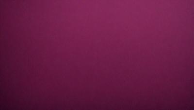 The primary subject of the image is a large, purple wall. The setting is a room with a pink background. The visual style is a close-up of the wall, which gives a sense of depth and texture. The dominant colors are purple and pink, creating a warm and inviting atmosphere.