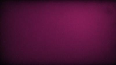 The primary subject of the image is a purple background. The setting is a dark, purple room with a pinkish hue. The visual style is a close-up of the purple background, which creates a moody and dramatic atmosphere.