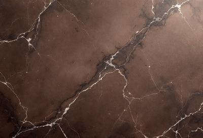 The image features a marble-like surface with a brown and white color scheme. The primary subject is a close-up of the surface, showcasing its texture and pattern. The setting is a room with a brown and white marble wall, which adds to the overall atmosphere of the space. The visual style is a close-up of the marble wall, emphasizing its unique texture and design.