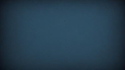 The primary subject of the image is a blue sky with no clouds. The setting is a vast, open space with no visible landmarks or objects. The visual style is a black and white photo, which adds a timeless and classic feel to the image. The colors and mood are predominantly dark and moody, with the blue sky serving as the main focal point.