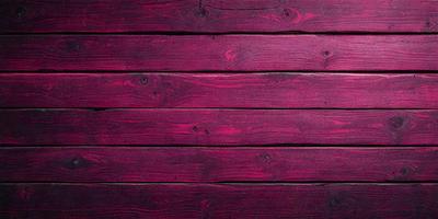 The primary subject of the image is a wooden wall with a red color. The setting is a room with a wooden floor. The visual style is a close-up of the wooden wall, showcasing its texture and color. The dominant colors are red and brown, creating a warm and cozy atmosphere.